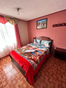 a bedroom with a bed with a red wall at Nuevo Horizonte in Pasto