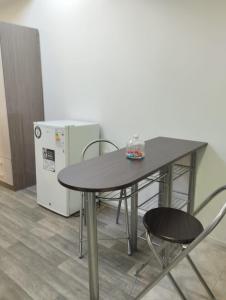 einen Tisch, 2 Stühle und einen Kühlschrank in der Unterkunft Apartamento cerca del Humedal Tres Puentes in Punta Arenas