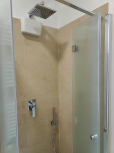 a bathroom with a shower with a glass door at Roma amoR Vitinia in Vitinia