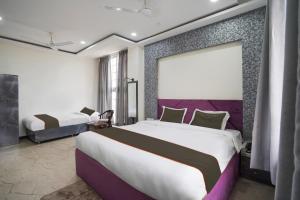 1 dormitorio con 2 camas y ventana grande en Hotel City Pride, en Raipur