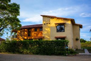 una casa amarilla con techo rojo en Villas Panaca Portal 1 en Quimbaya