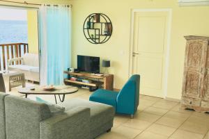 a living room with a couch and a tv at Appartement met prachtig uitzicht op zee! in Jan Thiel