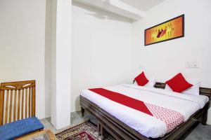 a bedroom with a bed with red pillows at Super OYO Flagship Blossom Inn Burari in New Delhi