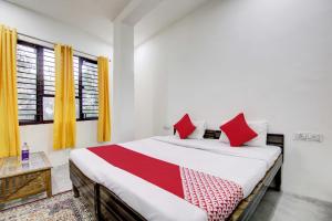 sypialnia z dużym łóżkiem z czerwonymi poduszkami w obiekcie Super OYO Flagship Blossom Inn Burari w Nowym Delhi