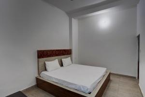 1 dormitorio pequeño con 1 cama con sábanas blancas en OYO Sky Line en Ghaziabad