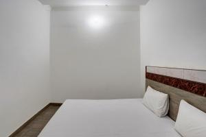 1 dormitorio con 1 cama blanca y 2 almohadas en OYO Sky Line en Ghaziabad
