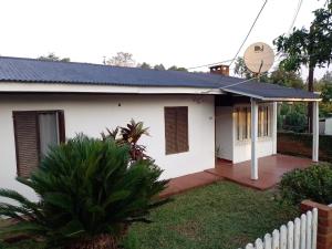 a white house with a solar roof at La esquina in Dos de Mayo