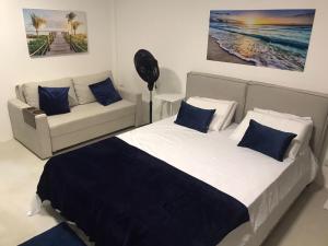 タマンダレーにあるStudio Praia dos Carneiros Tamandareのベッドルーム(ベッド1台、ソファ付)