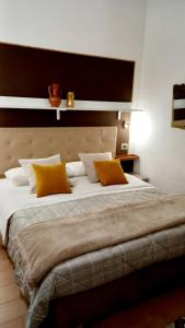 une chambre avec un grand lit avec des oreillers jaunes dans l'établissement La corte di Angelica, à Sciacca