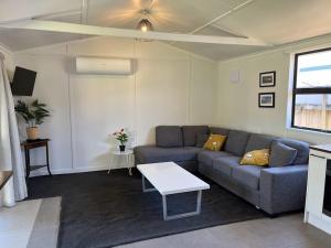 a living room with a couch and a table at Walk to the Water - Whangamata Holiday Home in Whangamata