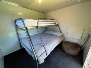 a small room with two bunk beds in it at Walk to the Water - Whangamata Holiday Home in Whangamata