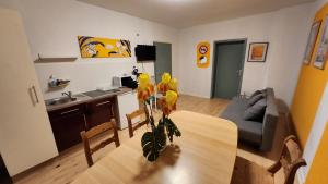 eine Küche und ein Wohnzimmer mit einem Tisch und gelben Blumen in der Unterkunft ELENA flat IRIS, Oberhausen Zentrum CentrO Westfield in Oberhausen