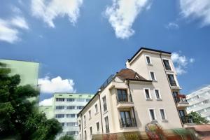 ein hohes weißes Gebäude vor einigen Gebäuden in der Unterkunft Mon Ami Apart in Studentski Grad Area in Sofia