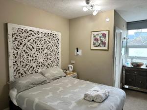 伯恩茅斯的住宿－Boho Beach House - Beach location，一间卧室配有一张床,上面有两条毛巾