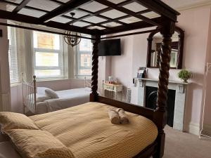 a bedroom with a canopy bed and a fireplace at The Boho - 4 min walk to beach & town in Bournemouth