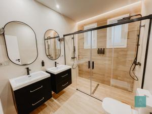 a bathroom with two sinks and a shower at PATIO DE LA MURALLA APARTAMENTOS in Córdoba