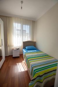 Un dormitorio con una cama con una manta de colores. en Cityhomes, en Dikili