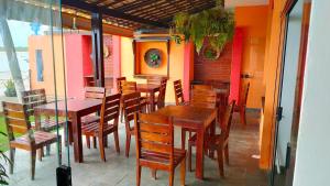 a restaurant with wooden tables and chairs on a patio at O Canto do Mar - Pontal do Coruripe in Coruripe