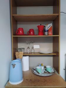 ein Regal mit Tassen und Geschirr auf dem Tisch in der Unterkunft Apartamento cerca del Humedal Tres Puentes in Punta Arenas