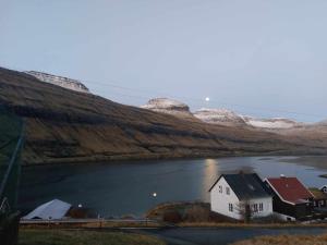 FunningsfjørðurFjord Guesthouse的位于水域中央的房子