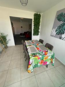 a dining room table with a colorful table cloth at Le Cocon Des Îles in Les Abymes