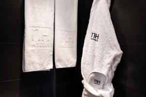 a white towel hanging on a wall in a bathroom at NH Ludwigsburg in Ludwigsburg