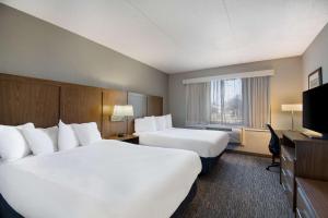 a hotel room with two beds and a television at Best Western Bridgeview Hotel in Superior