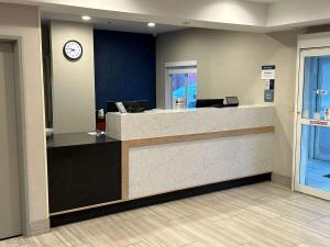 a lobby with a counter with a clock on the wall at Best Western Ottumwa Inn & Suites in Ottumwa