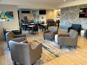 uma área de espera com cadeiras e mesas numa sala de espera em Best Western Ottumwa Inn & Suites em Ottumwa