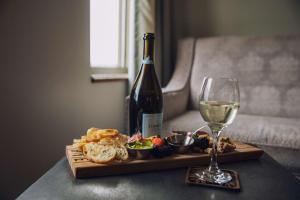 eine Flasche Wein, ein Teller mit Essen und ein Glas Wein in der Unterkunft CopperLeaf Boutique Hotel & Spa; BW Premier Collection in Appleton