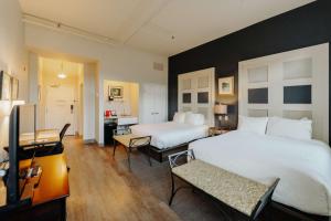 ein Hotelzimmer mit 2 Betten und einem Schreibtisch in der Unterkunft Mercer Hotel Downtown; BW Premier Collection in Stratford