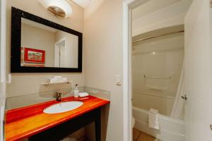 a bathroom with a sink and a mirror and a shower at Mercer Hotel Downtown; BW Premier Collection in Stratford
