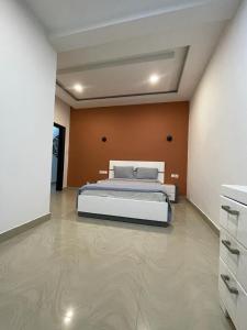 a bedroom with a bed and an orange wall at Appartement Haut Standing in Dakar