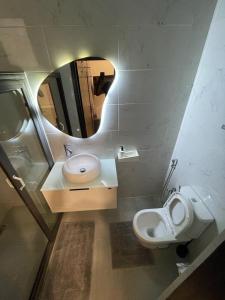 a bathroom with a sink and a toilet and a mirror at Appartement Haut Standing in Dakar