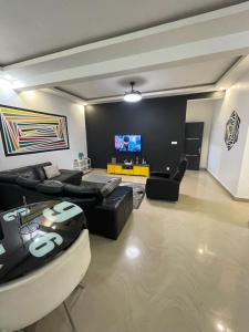a living room with couches and a flat screen tv at Appartement Haut Standing in Dakar