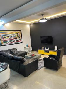 a living room with couches and a flat screen tv at Appartement Haut Standing in Dakar