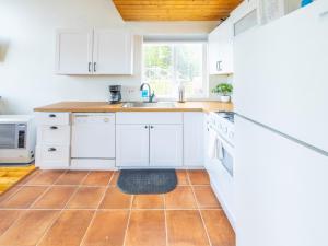cocina con armarios blancos y suelo de baldosa en Lake Vista Chalet - 1BR, Full Kitchen, Wi-Fi en Kenai