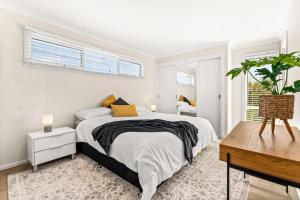 Un dormitorio blanco con una cama y una ventana. en Amongst the Palms Inverloch, en Inverloch