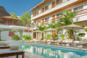 a hotel swimming pool with lounge chairs and umbrellas at Kaab Tulum in Tulum