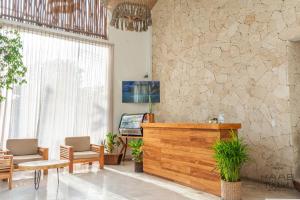 a lobby with a reception desk and a stone wall at Kaab Tulum in Tulum