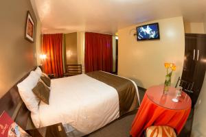 Habitación de hotel con cama y TV en UTASA VILLAREAL Inn, en Puno