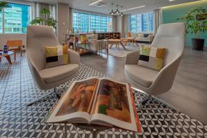 un vestíbulo con 2 sillas y un libro sobre una mesa en City Express Plus by Marriott Santa Fe en Ciudad de México
