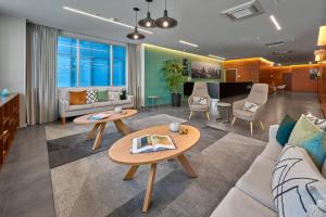 a living room with a couch and tables at City Express Plus by Marriott Santa Fe in Mexico City