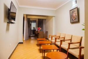 una habitación con sillas y mesas y una sala de espera en Bwizi Resort and Gardens, en Kanyigiri