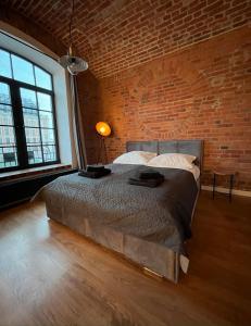 una camera con letto e muro di mattoni di Loft Apartment by Letrent a Żyrardów