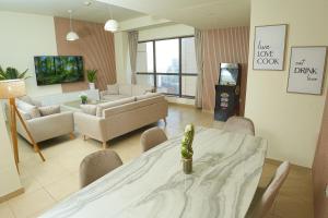 ein Wohnzimmer mit einem Tisch, Stühlen und einem Sofa in der Unterkunft Pure Sand - Luxury Hostel JBR Dubai in Dubai
