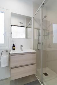 a white bathroom with a sink and a shower at Sepúlveda, tranquilo y con piscina by OUTIN in Seville