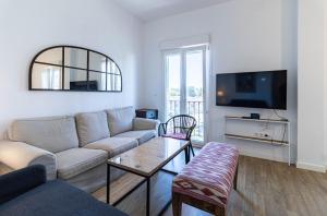 a living room with a couch and a flat screen tv at Sepúlveda, tranquilo y con piscina by OUTIN in Seville