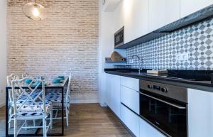 a kitchen with a counter and a table with chairs at Sepúlveda, tranquilo y con piscina by OUTIN in Seville