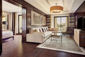 a living room with a couch and a tv at Fes Marriott Hotel Jnan Palace in Fez